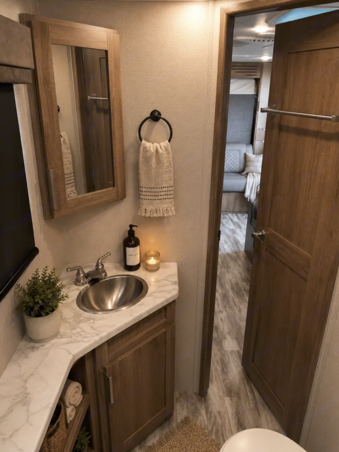 Bathroom vanity with a marble countertop, stainless sink and framed mirror